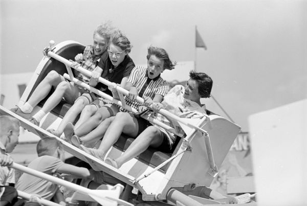 Four girls on the "Flying Coaster" carnival ride at the ESBMA festival on Kid's Day.