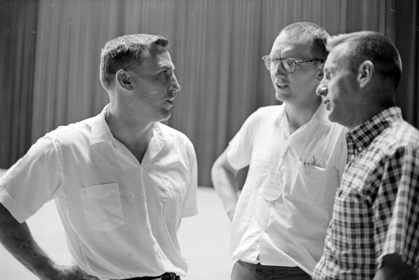Bob Odell, head football coach at Bucknell University, left, discussing football with Burt Hable, center, of Madison West and Harland Carl, right, of Neenah. Both of them are high school coaches. They all were attending lectures at the Wisconsin High School Coaches Assn. clinic, held at the University of Wisconsin Field House.