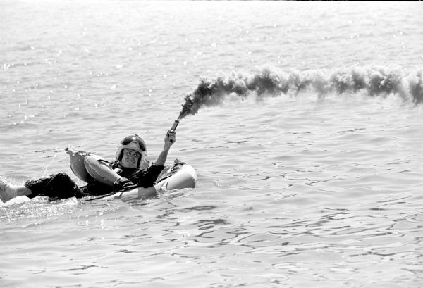 Truax Field pilots practicing water survival techniques in Lake Mendota near Warner Beach. The pilots, members of the 325 Fighter Interceptor Squadron, were hooked to a chair-like harness, dropped into the water and pulled backwards through the water by a speedboat to simulate the drag of an open parachute. Pilots were picked up by helicopters. The training is part of an overall Air Force program to improve survival of pilots when they parachute into open water.  It is good training for the kind of conditions encountered in the Vietnam area.