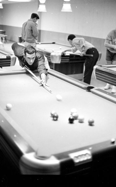 In one of a series of photographs showing the luxurious features of private dormitories on campus, Richard Mintz, Chicago, is shooting pool at Wisconsin Hall, a large dormitory for men.