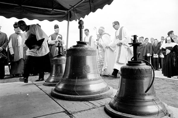Bishop William P. O'Connor of the Madison Catholic Diocese consecrates four new bells before they are raised in position at the new Holy Name Seminary building located at 702 S. High Point Road in Madison.
The bells, cast in France, range in weight from 320 to 1,440 pounds. 
The bells are named Spirit of Prayer, Humility, Obedience, and Sacrifice in accordance with Church custom. The bells were donated to the diocese by the architectural firm of Krueger, Kraft, and Associates.