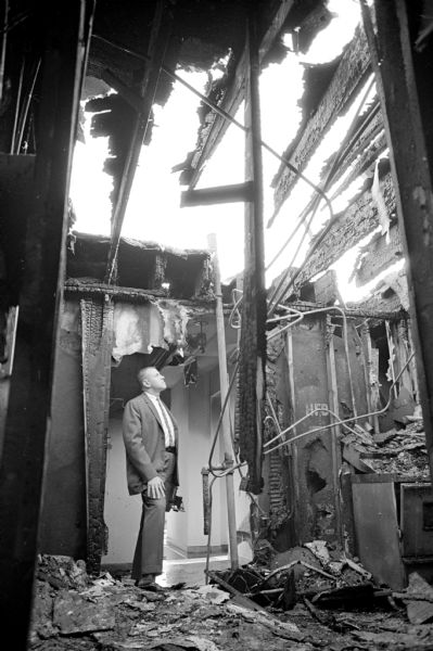 Close to $40,000 in damage caused by a workman's torch occurred at the
newly constructed Imperial Apartments located at 3803 Monona Drive, Monona, adjacent to the Eastside Businessmen's Club. Shown inspecting the fire damage is Monona police investigator William Diebold.