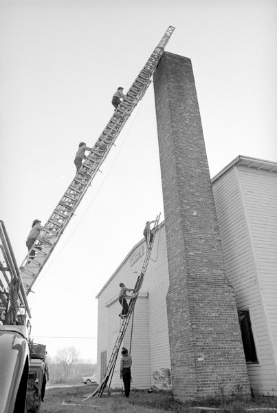Madison firefighters shown scaling ladders at the first permanent training center. It was originally a military theater for Truax Field and then the Madison Skating club rink on Wright street.