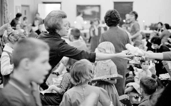 Mary Collentine helping distribute presents at the Christmas party given by the Madison Junior Woman's Club for their children.