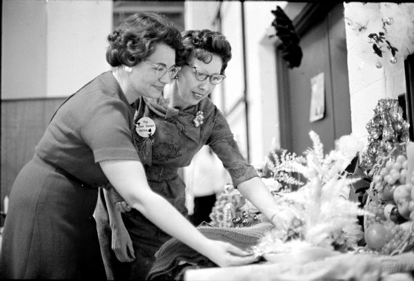 The DeForest and Waunakee Homemakers Clubs were the two hostess groups for the Christmas Tea. Mrs. Edward Murphy and Mrs. Edwin Stremer, both of Waunakee, are admiring the holiday exhibits.