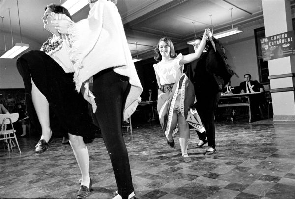View of people dancing. One from a series of photographs of a West High School Spanish class.