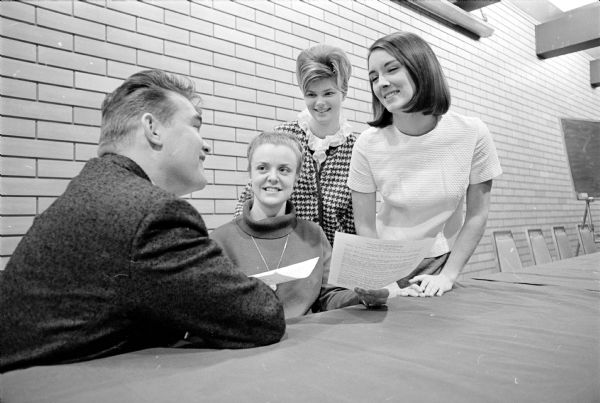 Contestants register for the annual Miss Madison contest sponsored by the Madison Junior Chamber of Commerce. Jerry Sheehy, 5005 Sherwood Road, is chairman of the pageant. Shown accepting registrations is Pete DeRemer, entries chairman, with two contestants, left to right: Patricia Wilson, DeForest; and Joan Rider, Miss Madison East, 917 E. Dayton Street; and Abbie deBuhr, present Miss Madison of 1964.