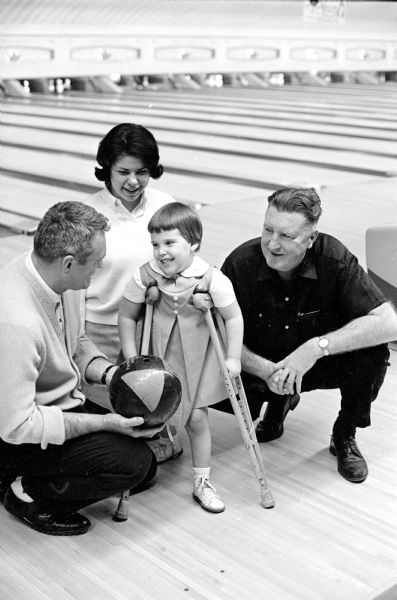 Bowlers are asked to donate 50 cents to enter the annual March of Dimes bowling competition. Shown left to right, are: Chuck Atkins, Maureen Richman, Lori Zenke (4), daughter of Mr. and Mrs. Edwin Zenke, 3829 Ridgeway Avenue; and Connie Schoegler.