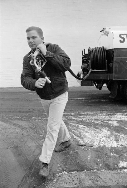 Gregory Herring is shown working on an asphalt paving construction crew for the Struck and Irwin Co., one of several jobs he worked on weekends and vacations to put himself through Ag school at the U.W.