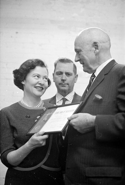 The State Bar of Wisconsin presents a plaque to Felice M. Goodman, 1015 Harrison Street, for writing an article entitled: "What A Wife Should Know" for the Family-Women Section of the <I>Wisconsin State Journal</I> (January 17, 1965 issue).
Mrs. Goodman has been a part-time employee of the newspaper's society staff for many years and is the widow of Joseph Goodman, a Madison lawyer who died in 1964. Shown, left to right, are: Mrs. Goodman, accepting the plaque; Philip Habermann, executive director of the State Bar Assn.; and Lyall T. Beggs, president of the State Bar of Wisconsin.
