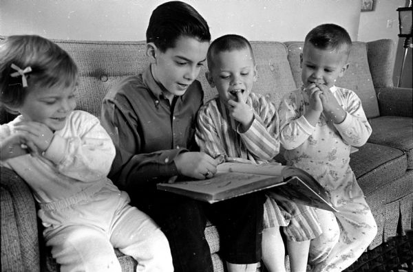 David Humphrey, 12, a trained baby sitter, is shown reading to Ann Marie Upham, 3; her brother, Tommy, 4 1/2; and Rusty Sherlock, 3 1/2 at the Upham home in Sun Prairie.