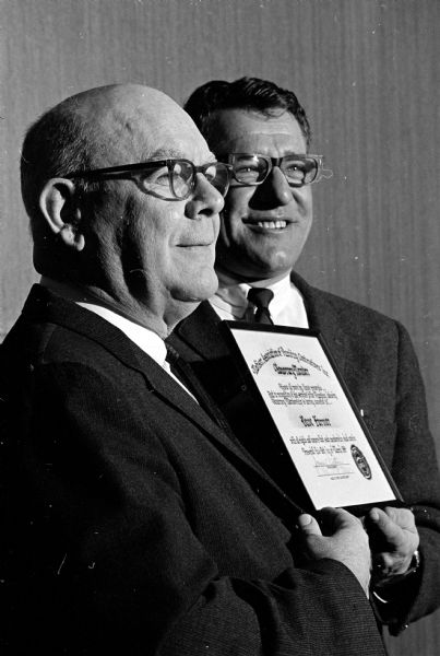 The Madison Assn. of Plumbing Contractors, Inc., meeting at Welch's Embers Supper Club, present honorary memberships to David Farmer, 4409 Winnequah Road, former secretary-treasurer of Hyland-Hall and Company, and Richard C. Royston, 1010 Oakland Avenue. Shown presenting a plaque to Mr. Farmer (left) is James E. Pertzborn (right), 610 S. Prospect Avenue, president of the association.