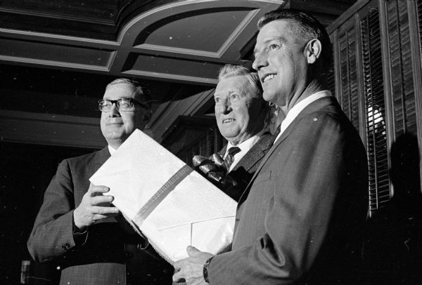 A testimonial dinner and a gift were given to Clarence (Connie) Parr after retiring from 27 years as supervisor of the Federal Housing Administration. Shown at the presentation were, left to right:  Lawrence Katz, Milwaukee, state FHA director; Parr; and Donald Sanford, toastmaster and testimonial chairman.