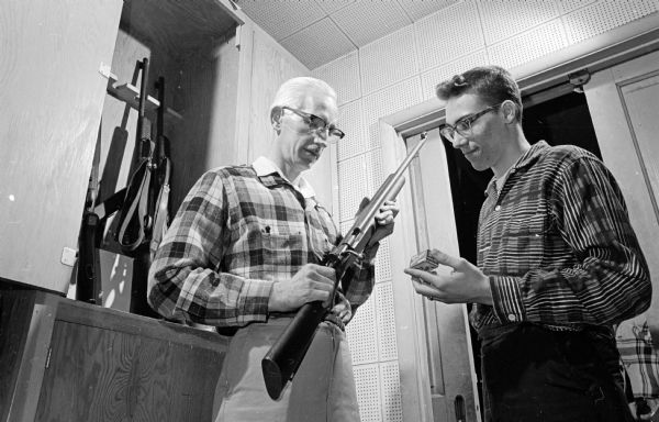 Photograph from the column "What Do YOU Say?" answering a question about firearms control. It features Jerry Teasdale, an instructor in Madison's Sportsmen's Club Junior rifle program, showing a rifle to David Dulin, 16.