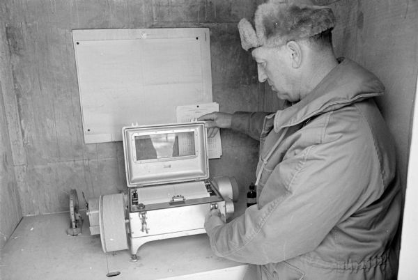 Keith Brigham is shown checking the U.S. Geological Survey stream gauging station located at the Yahara river locks on Lake Waubesa near McFarland.