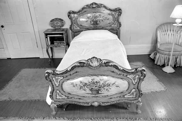 Old Rectory Sales of Grace Episcopal Chruch is in charge of the sale of furnishings of the historic Louis M. Hobbins house built by E.M. Fuller on the shores of Lake Mendota at 16 Fuller Court in Fuller's Woods in Maple Bluff. Mrs. Hobbin's father, E.M. Fuller, a prominent lumberman, built the Fuller Opera House on E. Mifflin Street in Madison. Mr. and Mrs. Hobbins and their only daughter Shirley, moved into the house after the deaths of Mr. and Mrs. Fuller. An unusual item for sale is a Venetian rococo green and beige enameled single bed, accented in gold, with floral decorations. The ornate bed, brought from Italy by the Fullers, has a matching night stand.