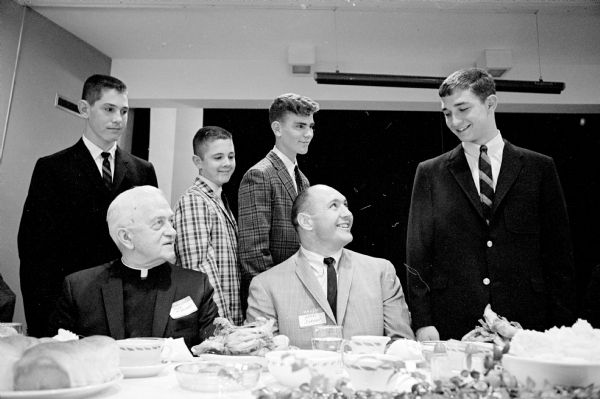 Our Lady Queen of Peace parish is holding the annual athletic banquet at the church auditorium. Shown (seated) are Msgr. Francis L. McDonnell, and Henry Jordan, Green Bay Packers, guest speaker, and (standing L-R) Don Esser, most valuable football player; Mike Riley, sportsmanship award winner; Dan Baker, most valuable basketball player; and Denny O'Brien, captain of Chi-Rho basketball team.