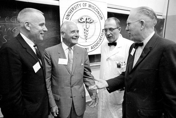Dr. Frank L. Weston, right, retiring president of the Wisconsin Medical Alumni Association, talks with his successor and two of the association's award winners during the Annual Alumni Day activities. At left is Dr. Herbert Pohle, Milwaukee, the new president. Second from left is Dr. Horace Kent Tenney, Jr., Madison, winner of the emeritus faculty award, and third from left is Dr. Richard Wasserburger, a professor in the medical school, recipient of the Distinguished Teaching Award.