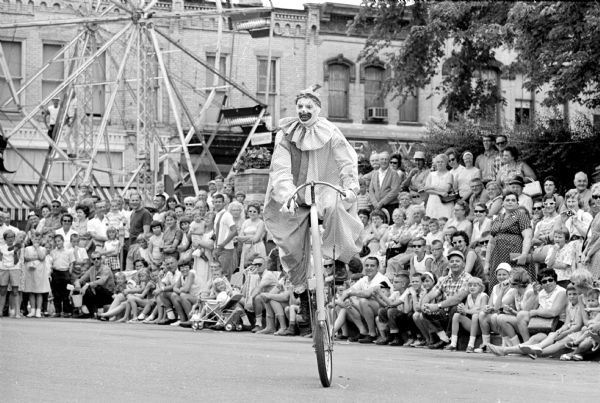 A Madison Knights of Columbus clown wheeling his unicycle along the parade route during the annual circus celebration parade in Baraboo.