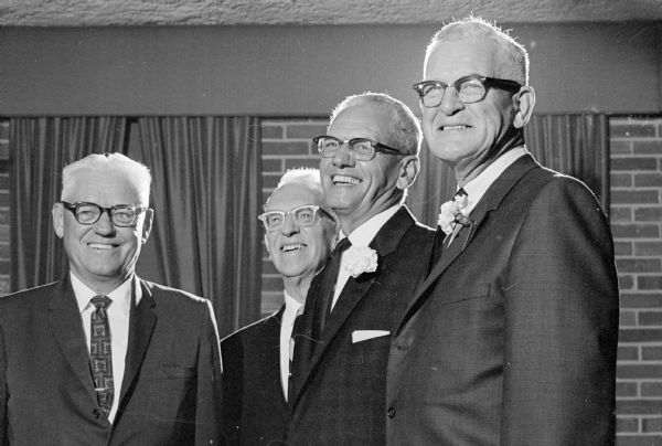 Two members of the state Conservation Department being honored at their retirement. George Sprecher, left, assistant department director; and Lew Laughlin, right, license section supervisor, greet Henry T. (Hank) Danielson, second from left, and Elmer R. Colwill.