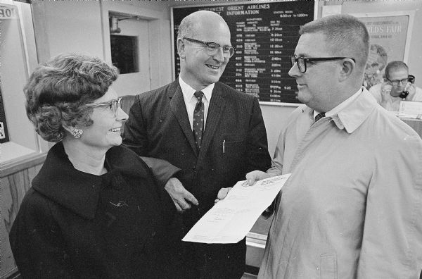 Bill Togstad, president of the Madison Builders Association, with his wife, meeting Henry M. Shine, Jr., director of the National Housing Center in Washington prior to leaving for a trip to visit European cities to check their building ideas.