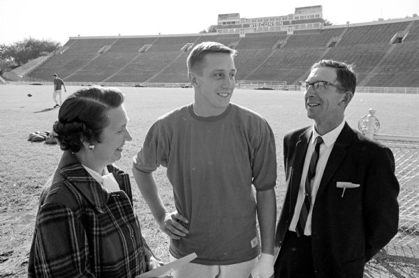 Celebrating Parents' Day at the University of Wisconsin are Mr. and Mrs. Norman Fronek of Antigo, parents of Badger football captain Dave Fronek.  Parents and son are shown at Camp Randall stadium.