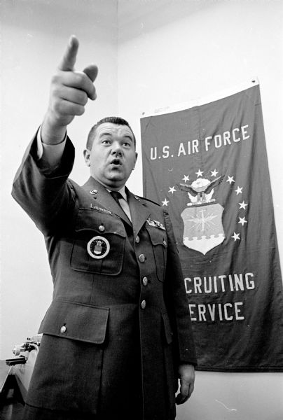 Sgt. Gerald Johnson is shown in front of a recruiting banner for the U.S. Air Force.
