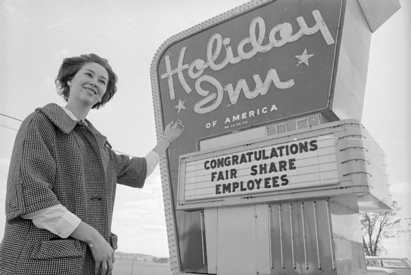Woman with Holiday Inn Sign with the message: "Congratulations Fair Share Employees." United Givers Fund Campaign.