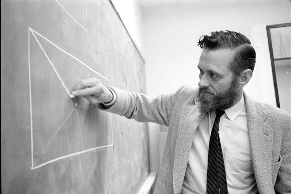 University of Wisconsin Mathematics Professor Donald W. Crowe explaining a math problem on how to cut up a rectangular cake into equal size acute triangles to high school students at the third annual Wisconsin mathematics talent hunt.