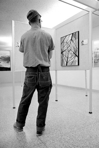 Carl Schwarz, Sauk City, admiring some of the art work in the "Art of Extra High Voltge" exhibit showing at the Wisconsin Center, 702 Langdon Street. The exhibit features 62 paintings done by public utility employees from across the country and is sponsored by Madison Gas & Electric and the University of Wisconsin College of Engineering.