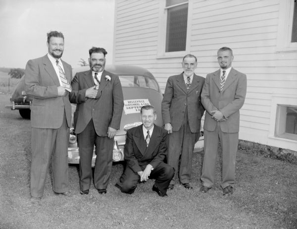 Five men standing behind a car with a sign that reads: "Belleville Centennial and Fair Sept 12."