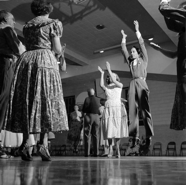 Harold and Hazel Woods and John and Alberta Lythjohan are shown square dancing in the gymnasium at Frank Allis School.