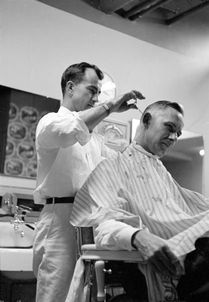 Barber Roy Brumley cutting the hair of R.J. Best in the Belmont barbershop.