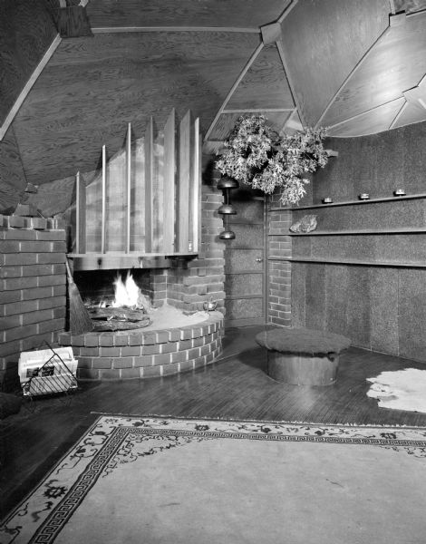 Interior view of the living room floor in the James Dresser dome home at 5126 Tomahawk Trail. The house is also known as the Thomas A. and Stacy H. Littrell House, the David C. Mortensen House, and the Smart House. The house was built in 1952-53 by architect James Dresser for his family. He studied for a time at Frank Lloyd Wright's Taliesin in Spring Green. Dresser called it the Sunflower House due to its round shape and the awnings over the triangular windows.

The house is technically a monodome — a concrete shell built on a radial framework of curved steel beams. Examples of these beams are visible in the carport structure. The lower portion of the house is subterranean and the upper portion is centered around the kitchen. Half of the home is a living and dining area open to the kitchen. The other half of the house was originally one small master bedroom, a bathroom and two tiny children's bedrooms. The original walls were cork and all the rooms of the home, except the bathroom, were originally open to the dome.