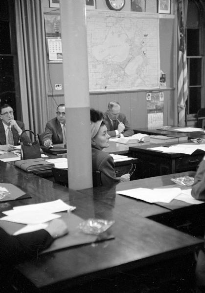 Spectators and members at the Madison City Council meeting on November 24, 1953.  At the left, is Carl H. Wilhelm, council president. Alder Ethel Brown is in the foreground and City Attorney Harold E. Hanson is at the right.