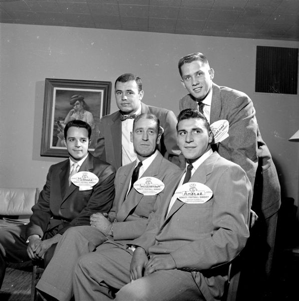 Some of the principals at the annual football banquet. Seated left to right: Gary Messner, 1954 captain-elect; Coach Ivan Williamson; Alan (the Horse) Ameche, most valuable player. Standing left to right: Roger Dornburg and Jerry Wuhrman, co-captains of the 1953 team. Each man is wearing a football-shaped name tag.