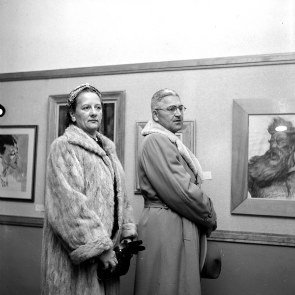 Mr. and Mrs. Irving J. Maurer studying paintings at Madison Art Association Collectors' Show in Scanlan Hall at the Madison Vocational school.