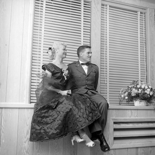 Guests at the Truax Field Officers Club formal "debt party" and dance celebrating the opening of the new clubhouse. Lt. R.A. Weber and Mrs. Weber chose a high window ledge as a good observation point from which to watch the dancers.