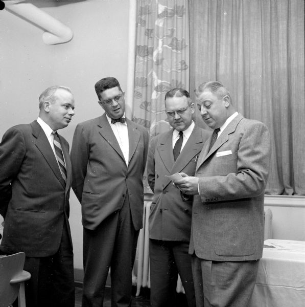 A.E. Whitford, W.K. Mansfield, Ted M. Meloy, and Carl Regenberg (left to right) discuss plans for the drive to raise $75,000 for the Dane County chapter of the National Foundation for Infantile Paralysis.