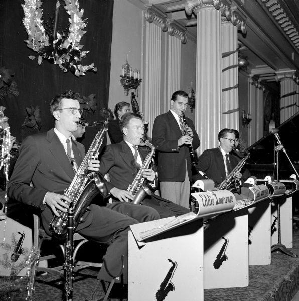 The annual Christmas Charity Ball held at the Loraine Hotel. This is the woodwind section with saxophones and clarinet of Eddie Lawrence's band, which played in the Crystal Ballroom. Left to right are: Boris Josheff, Emery MacMillan, Larry Borenstein, and Bob Homme, all members of Local 166, American Federation of Musicians.