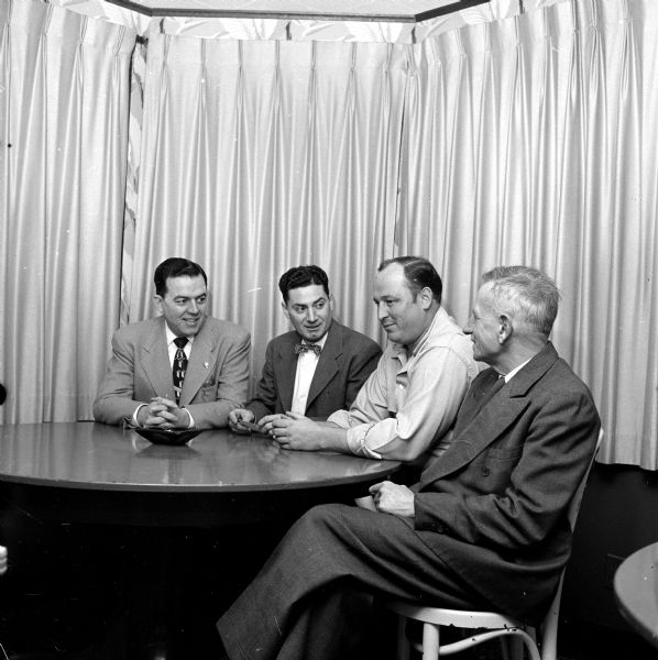 Four members of the West Side Business Men's Association visiting before the meeting. From left are: C.A. Lewis, J.J. Quartuccio, Obie Quam, and Richard Lawrence. Obie Quam manages the Nakoma Golf Club, where the meeting was held.