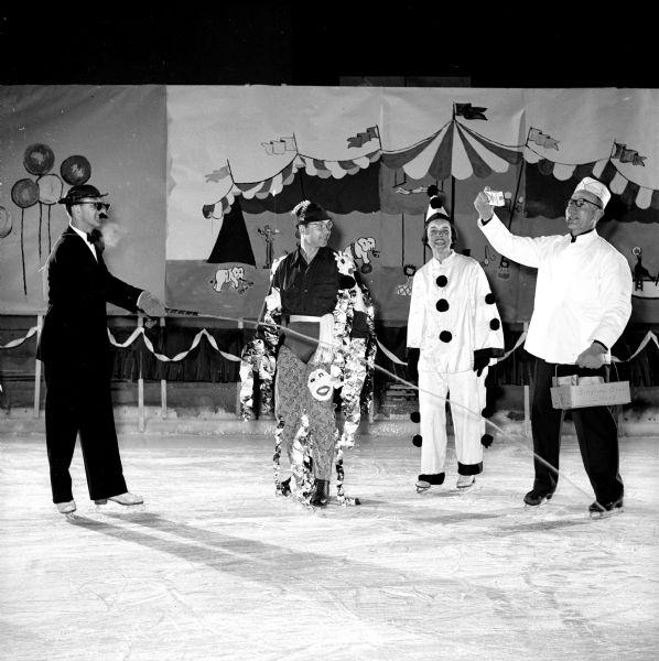 Members of the Madison Figure Skating Club held their annual winter party at the Truax Field Arena. The event was organized on a circus theme. Arden Taylor is hawking Crackerjacks, while Ira Karsten, Mary Schmitz (dressed as a clown) and Don Baird are listening to his spiel.