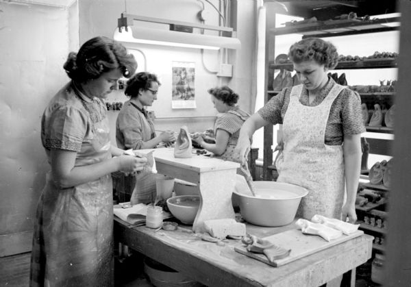 Gloria Johnson, Bonnie Kinne, Marie Sachtjen, and Irene Ellestad glazing figures for the kiln at Ceramic Arts Studios, 8 North Blount Street. 