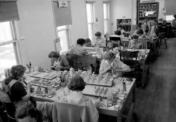 Women applying the finishing touches on an assortment of ceramic figures at Ceramic Arts Studios, 8 North Blount Street.