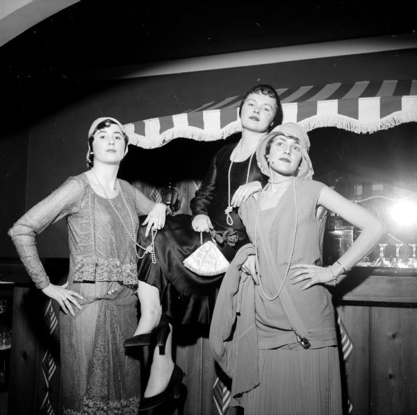 "Ads and Fads," Madison Advertising Club Women's Night, held at the Hoffman House. Members are wearing fashions from the first half of the twentieth century, like that of flappers. Commentary at the event was by Mrs. Charlotte Peterson and music by Pat Sellegar. Shown are (left to right): Sally Mohar, Joan Connor and Louise Stehr.