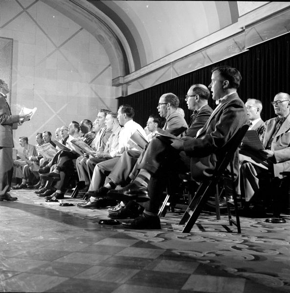 The local group of the Society for the Preservation and Encouragement of Barbershop Quartet Singing in America (SPEBSQSA) rehearsing before an international contest in Washington, D.C. Members shown are (left to right): Jerry Ripp, Dave Fauerbach, Vaughn Liscum, Chester Maas, Ervan Adler, Eugene Day, John R. Krause, Philip M. Davies and Dr. Fred Lantz.