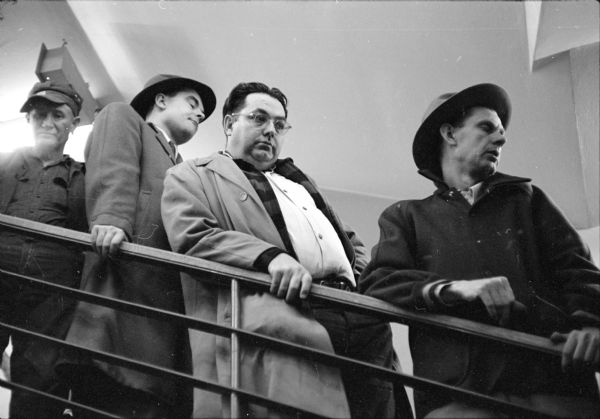 Ed Arpin, Harold Swenson and Bob Scholl waiting in line on the stairway to buy tickets for the Milwaukee Braves baseball team in the branch office, located in the basement of The Hub clothing store in downtown Madison.