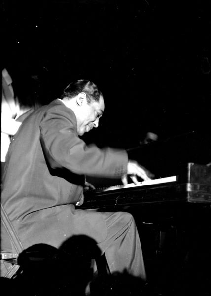 Duke Ellington at the keyboard at a jazz big band concert in the University of Wisconsin Stock Pavilion.
