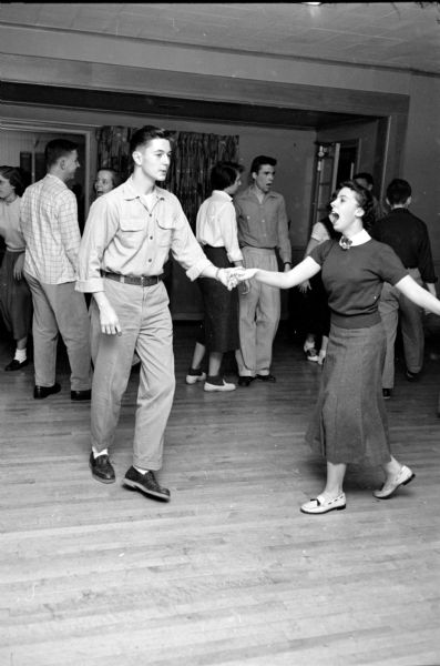 The Shorewood Hills Community League sponsored a dance class for teenagers at the Blackhawk Country Club that was taught by Arthur Murray instructors. Bob Bloss and Susan Stauffer, holding hands, enjoy a swing dance.