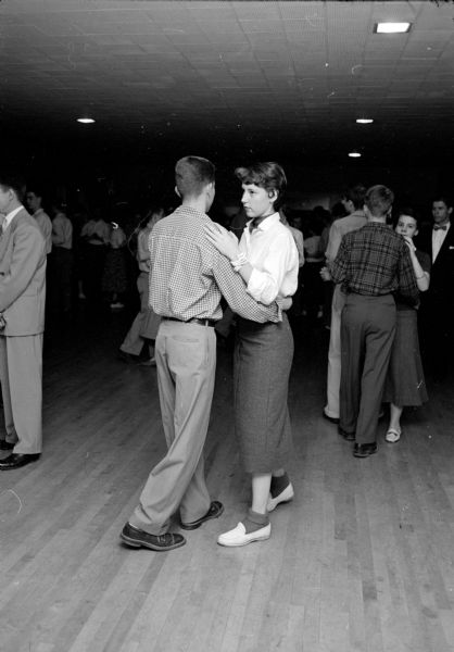 The Shorewood Hills Community League sponsored a dance class for teenagers at the Blackhawk Country Club that was taught by Arthur Murray instructors. Tom Mohs is dancing with Mary Sewell, who is wearing loafers and dark-colored bobby socks.